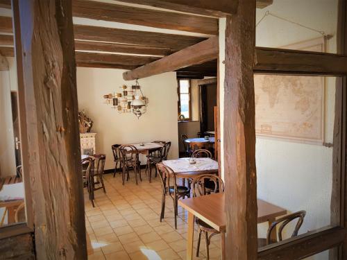 um restaurante com mesas e cadeiras num quarto em Hôtel Au Vieux Moulin em Lapoutroie