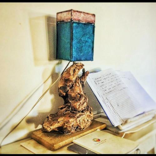 a lamp sitting on top of a table with a book at Dimora A' Turri di GN Real Escapes in Ribera