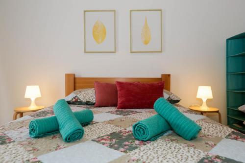 a bedroom with a bed with blue pillows on it at Casa do Califórnia in Ribeira Grande