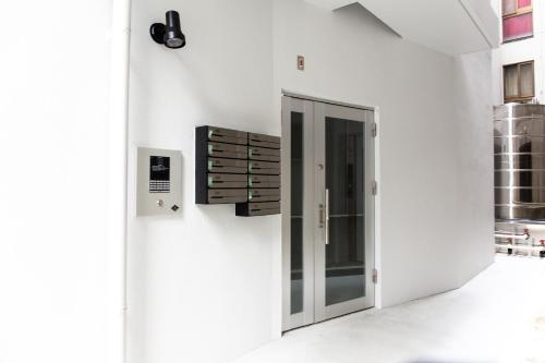 a white building with a door on the side at Good Life Apartment in Naha