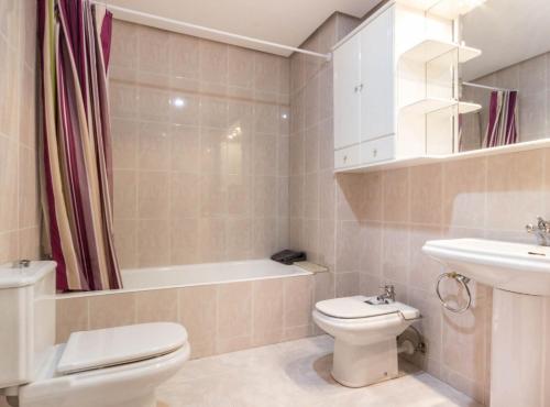 a bathroom with a toilet and a sink and a bath tub at Piso Señorial con vistas a la ria by Urban Hosts in Bilbao