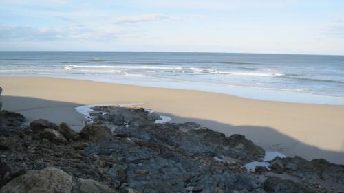 a beach with some rocks and the ocean at Hotel Balcón de San Bartolo in Barreiros