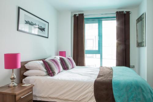 沃金的住宿－Oakdale at Cardinal Place，卧室配有带枕头的床铺和窗户。