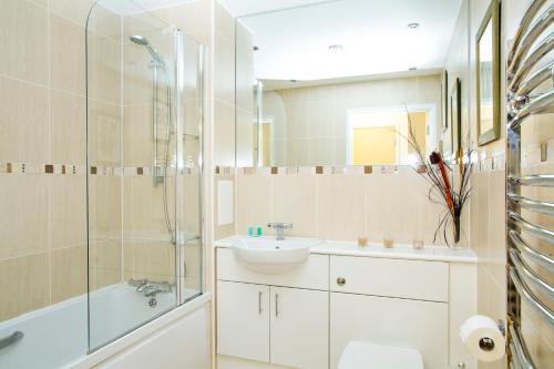沃金的住宿－Oakdale at Cardinal Place，浴室配有盥洗盆、卫生间和淋浴。
