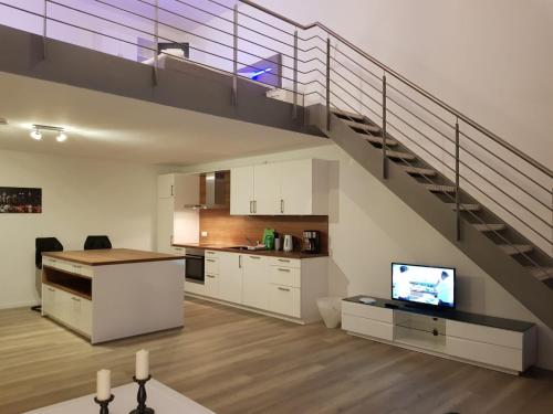 a kitchen and a living room with a staircase at WH Boardinghouse in Papenburg