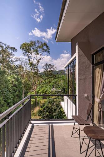 a balcony with chairs and a view of the forest at Sementra Hot Spring Nature Resort in Gopeng