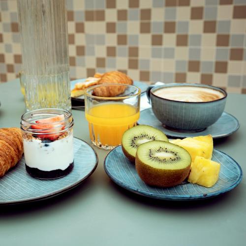 a table with two plates of food with fruit and juice at Condominio Monti Boutique Hotel in Rome