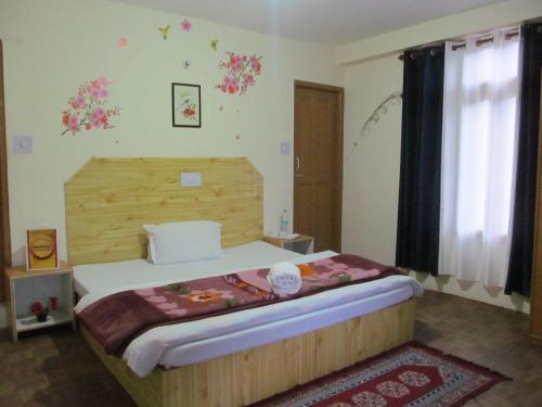 a bedroom with a bed with a wooden headboard at Manali Top Inn in Manāli