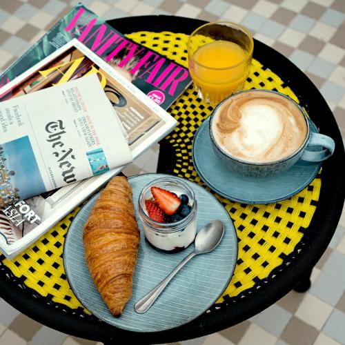 a table with two plates of food and a cup of coffee at Condominio Monti Boutique Hotel in Rome
