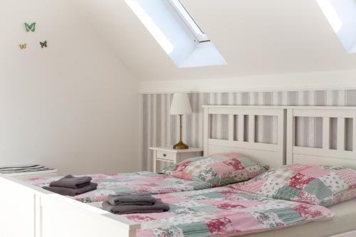 a white bedroom with two beds and a skylight at Landhof Potsdam in Potsdam