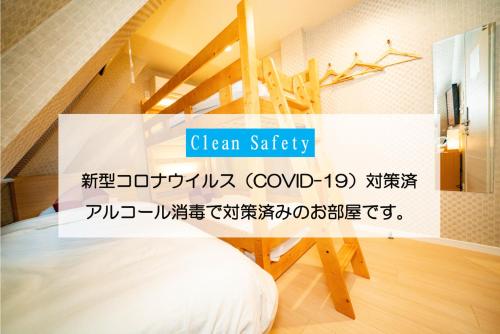 a room with a bed and a sign that reads clean safety at kaguya asakusa Women only guest house in Tokyo