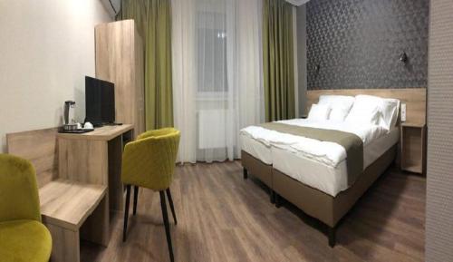 Dormitorio con cama, escritorio y TV en Viktória Panzió, en Dunaújváros