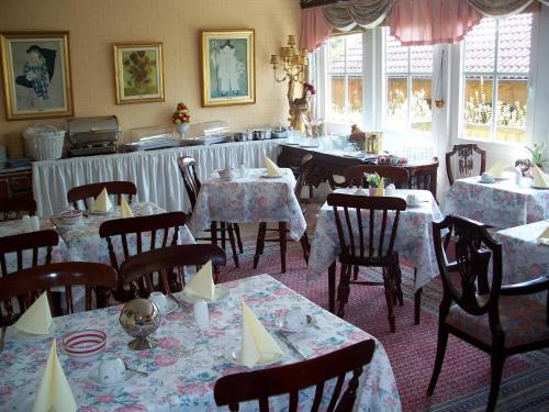 a dining room with tables and chairs and a room with tables and chairsktop at Hotel Barmstedter Hof in Barmstedt