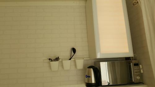 a kitchen counter with a microwave and some utensils at SJÖTORPS HOSTEL in Sjötorp