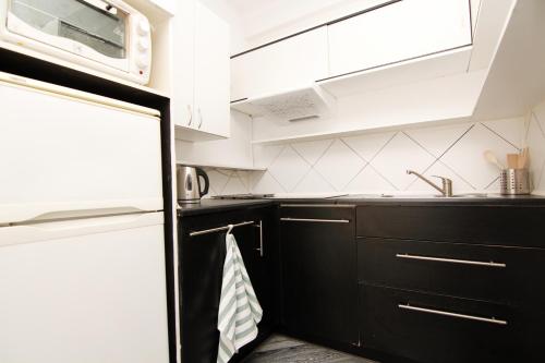 a kitchen with black cabinets and a microwave at Blue River - Niedzwiedzia in Wrocław