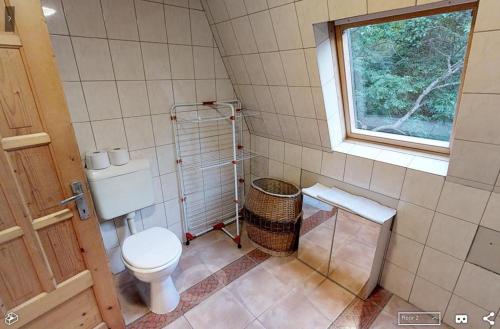 a small bathroom with a toilet and a window at Faház Hejce in Hejce