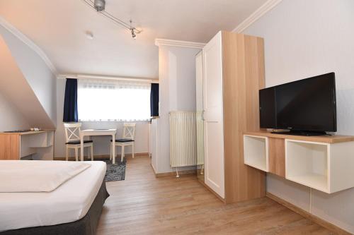 a hotel room with a bed and a flat screen tv at Bremer Apartmenthotel Superior in Bremen