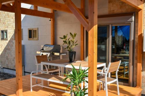 a patio with a table and chairs and a grill at Villa 777 Hakuba in Hakuba