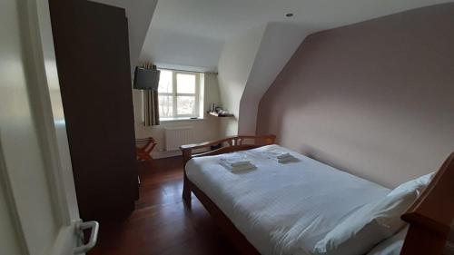 a small bedroom with a bed and a window at Inspiration Lodge in Anascaul
