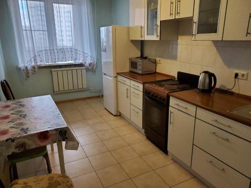 モスクワにあるMoskvorechyeの小さなキッチン(テーブル、冷蔵庫付)