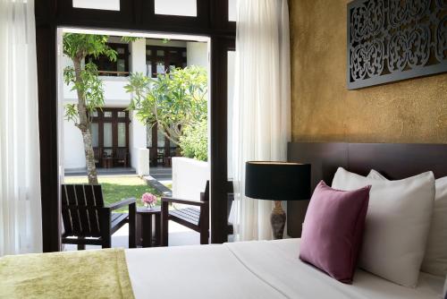 a hotel room with a bed and a view of a courtyard at Avani Kalutara Resort in Kalutara