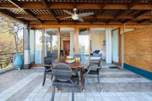 a patio with a wooden table and chairs at Xenios Dias Luxury Apartments With Sea View in Kato Daratso