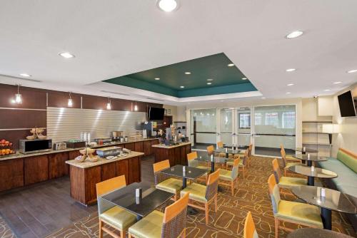 a restaurant with tables and chairs and a kitchen at La Quinta by Wyndham Houston Willowbrook in Houston