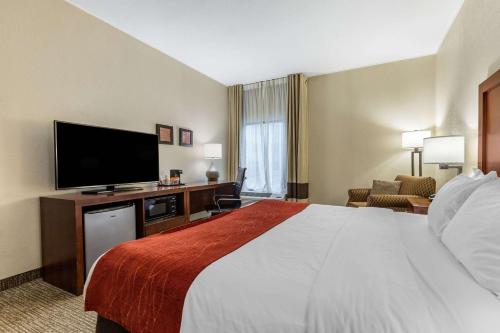a hotel room with a bed and a flat screen tv at Comfort Inn & Suites Clemson - University Area in Clemson