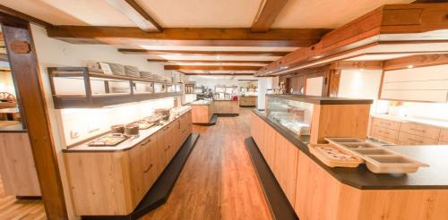 a large kitchen with wooden cabinets and counters at Hotel Engel - Familotel Hochschwarzwald in Todtnauberg