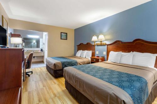 a hotel room with two beds and a desk at Econo Lodge Sturbridge Route 20 in Sturbridge