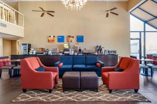 un hall d'entrée avec deux fauteuils rouges et un canapé bleu dans l'établissement Comfort Inn Pearl-Jackson, à Pearl