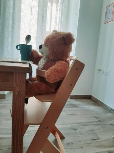 a teddy bear sitting in a chair at a table at Istrabella Apartment in Koper