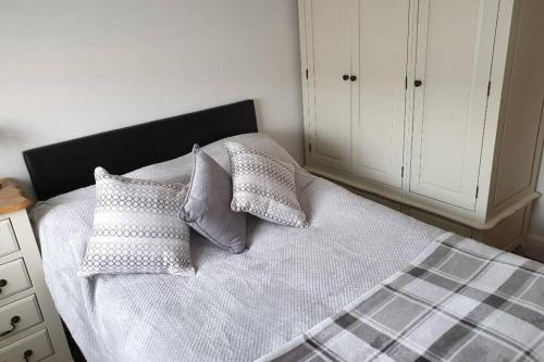 een slaapkamer met een bed met kussens erop bij A home away from home with a big welcome in Slades Green