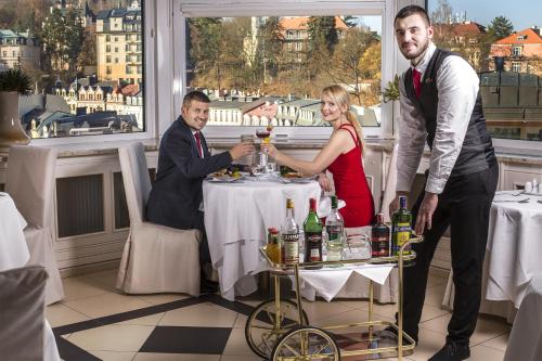 a group of people standing around a table with a blender at Bristol Vila Tereza in Karlovy Vary