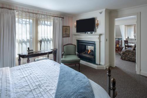 a bedroom with a bed and a fireplace and a television at The Inn at Thorn Hill in Jackson