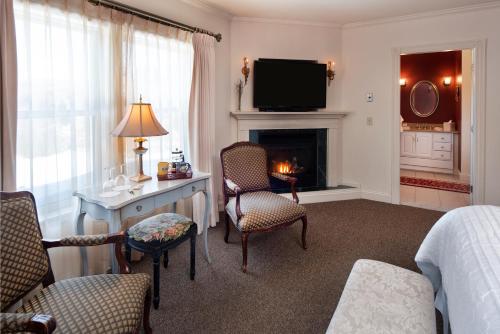 a hotel room with a bed and a desk and a fireplace at The Inn at Thorn Hill in Jackson