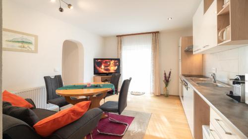 a kitchen and a living room with a table and chairs at Ferienwohnungen Presslauer Mori - Haus Irmgard in Sankt Kanzian