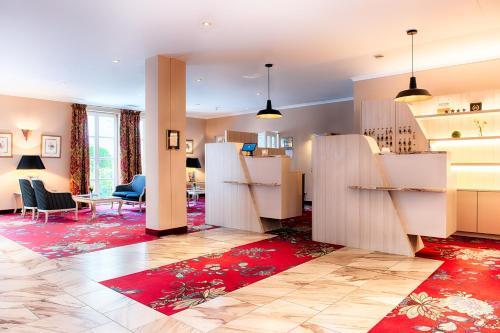 uma sala de estar com mobiliário branco e um tapete vermelho em ACHAT Hotel SchreiberHof Aschheim em Aschheim