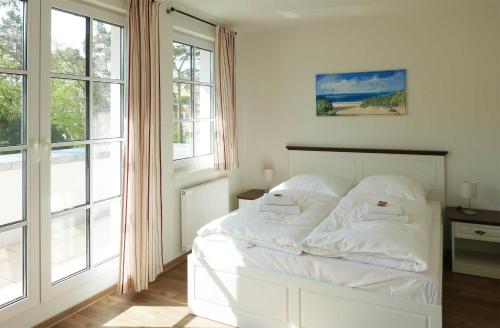 a white bed in a room with windows at Baabe Inselparadies Fewo Sandbank in Baabe
