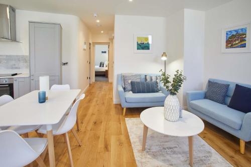 a living room with a white table and blue furniture at Host & Stay - The Old Sweet Shop in Whitby