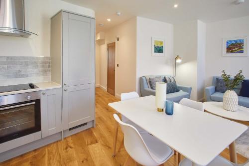 a kitchen and living room with a white table and chairs at Host & Stay - The Old Sweet Shop in Whitby