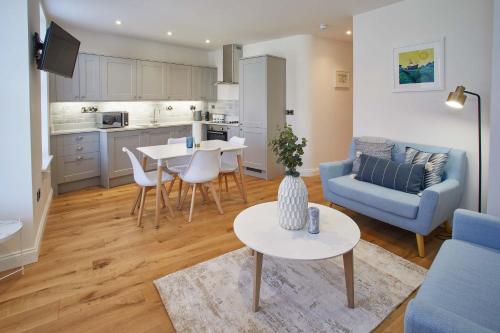 a living room with a blue couch and a table at Host & Stay - The Old Sweet Shop in Whitby