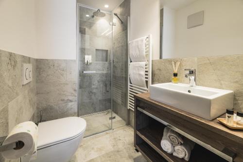a bathroom with a toilet and a sink and a shower at Aurela Mountain Chalets in Selva di Val Gardena