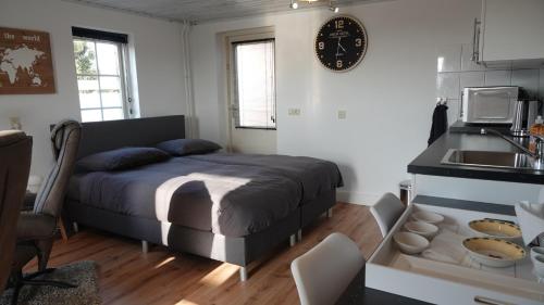 1 dormitorio con 1 cama y cocina con fregadero en B&B Bij Bronckhorst, en Steenderen