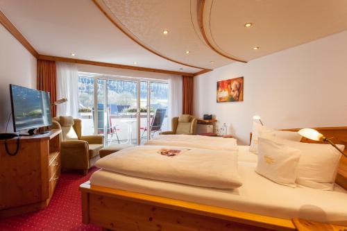 a hotel room with two beds and a television at Landhotel Voss im TalVital in Saalhausen