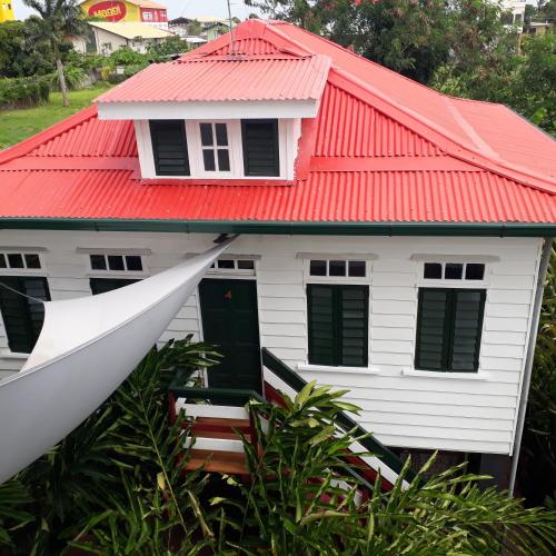 a white house with a red roof at Couleur Locale Paramaribo in Paramaribo
