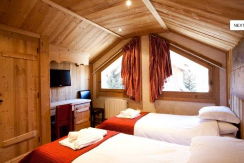 Un dormitorio con 2 camas y una ventana en una habitación en Chalet l'écureuil, en Méribel