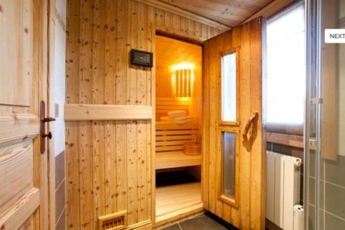 uma casa de banho em madeira com sauna numa casa em Chalet l'écureuil em Méribel