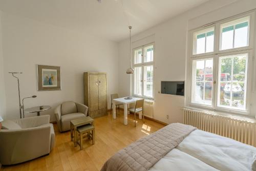 a bedroom with a bed and a chair and a desk at Fewo auf der Dominsel - SEEROSE in Brandenburg an der Havel