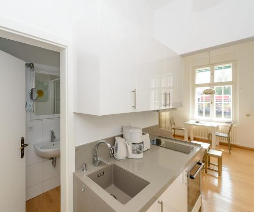 a white kitchen with a sink and a counter at Fewo auf der Dominsel - SEEROSE in Brandenburg an der Havel